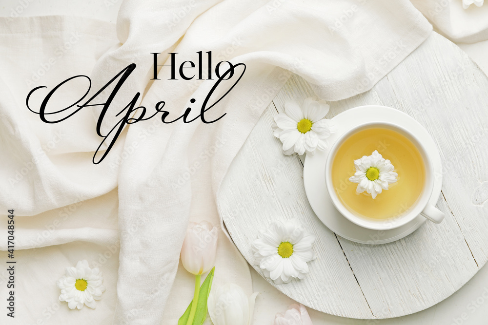 Beautiful composition with tea and spring flowers with text HELLO APRIL on light background