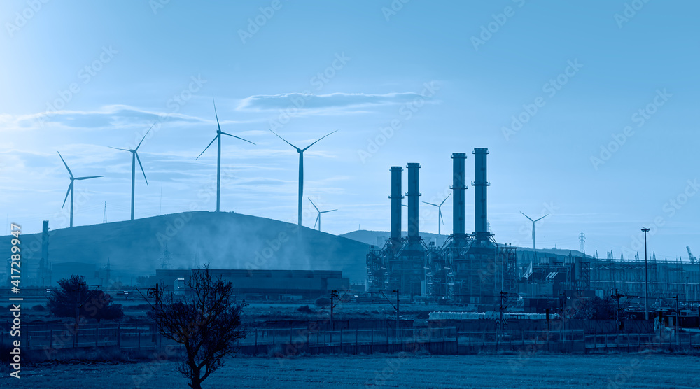 工业概念-带可再生能源风力涡轮机的天然气处理厂剪影