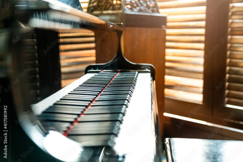 咖啡馆里无人的木质百叶窗背景的大钢琴