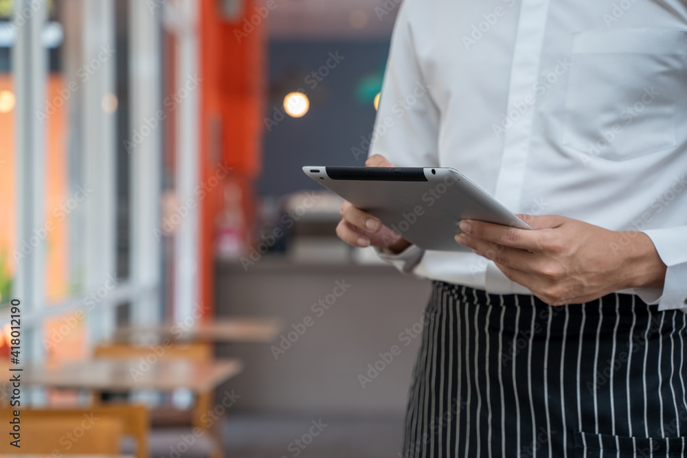 员工在咖啡店使用平板电脑并接受订单。