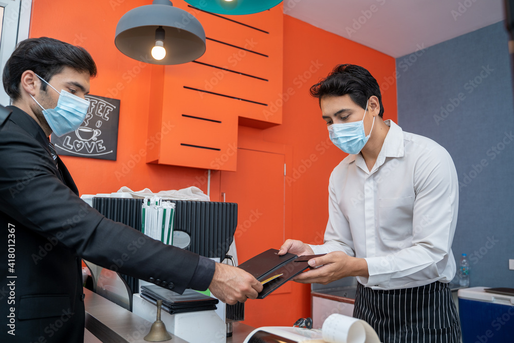 账单支付，顾客用信用卡向咖啡店服务员支付咖啡饮料。