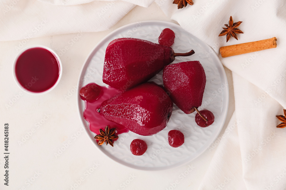 Plate with sweet poached pears in red wine on light background
