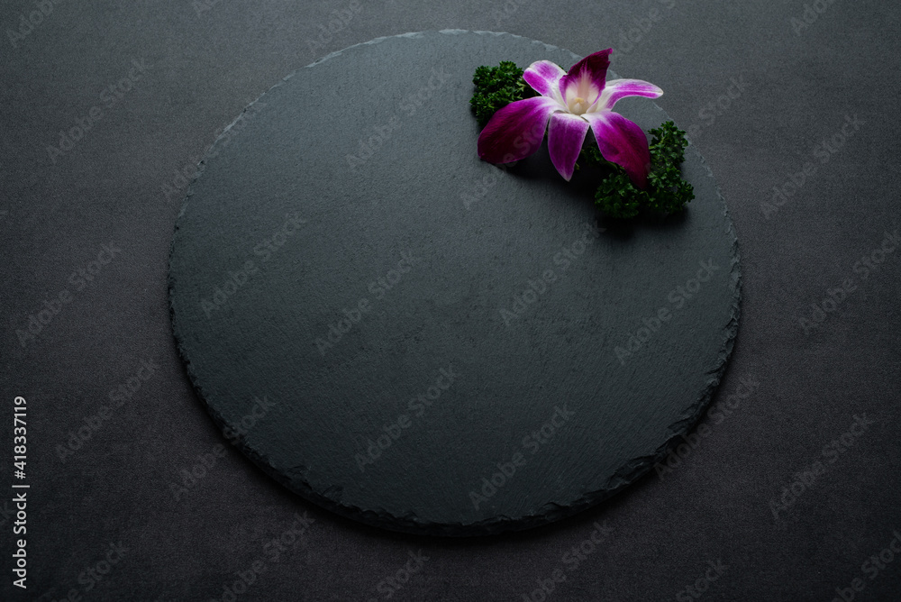 用兰花和欧芹装饰的黑色石板托盘