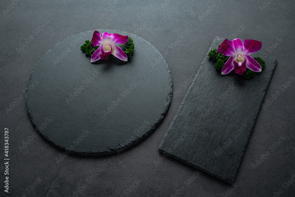 Black slate tray decorated with orchids and parsley