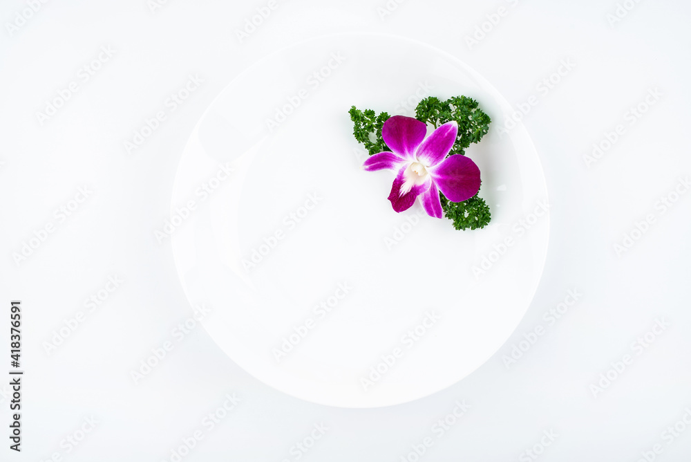 用兰花和欧芹装饰的白色空盘子