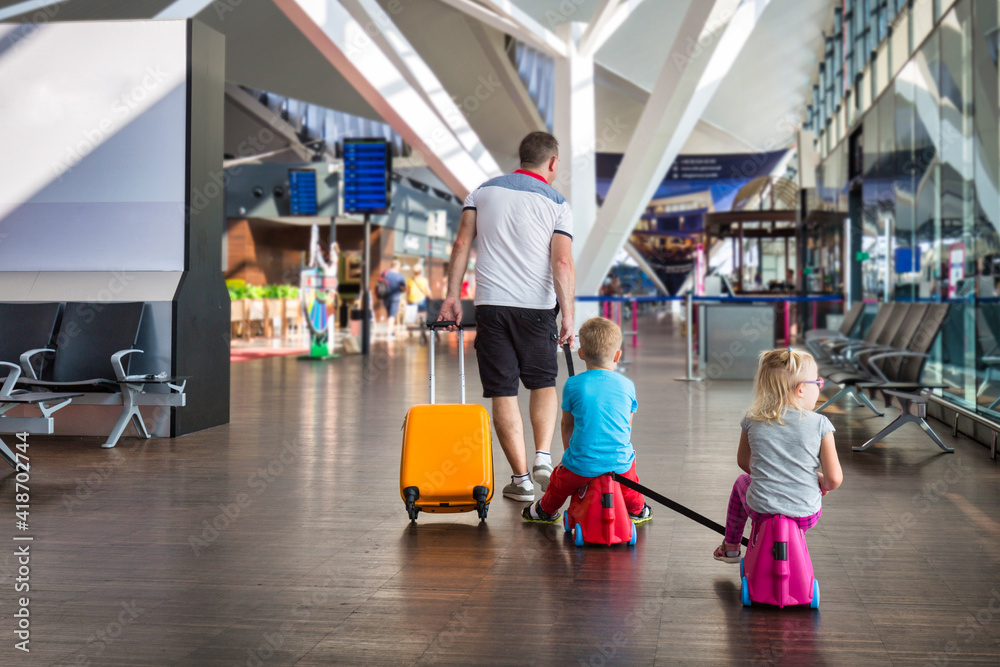 父亲带着两个孩子在机场候机楼一起度假