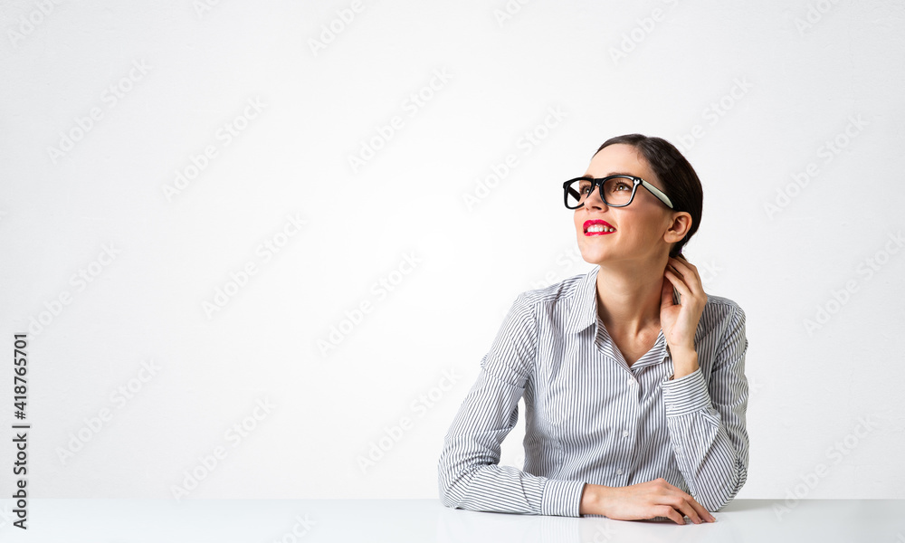 戴着眼镜坐在办公桌前的自信女商人
