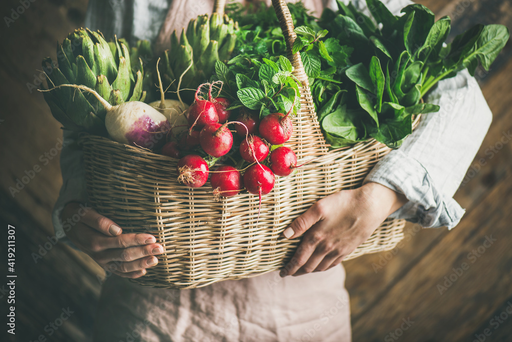 穿着亚麻围裙的女农民手里拿着一篮新鲜的有机花园蔬菜和绿色蔬菜，r