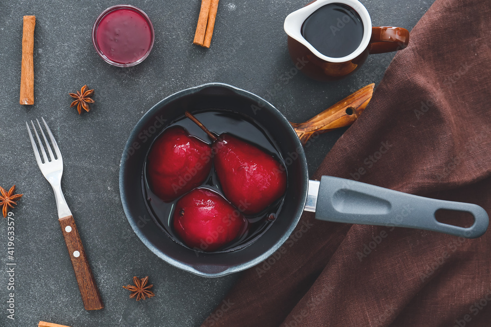 Pan of tasty poached pears in wine sauce on dark background