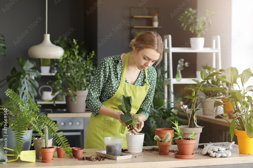 Young woman taking care of her plants at home