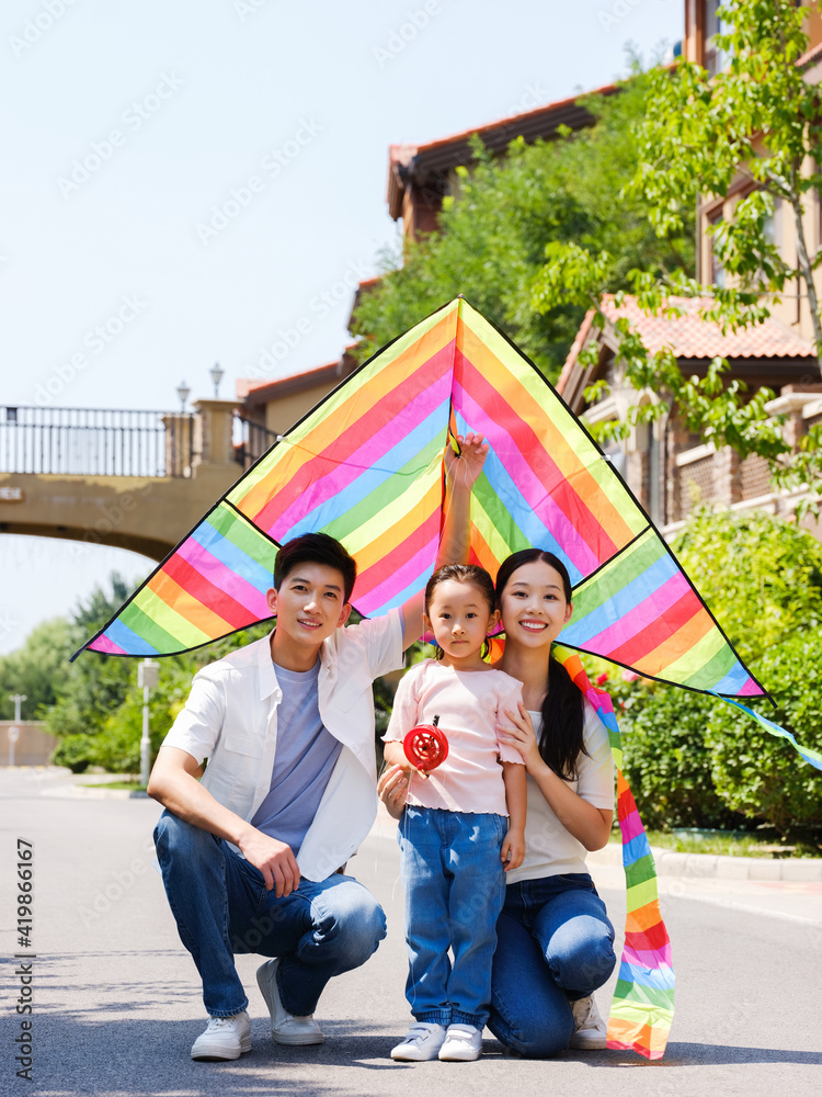 三个户外放风筝的幸福家庭