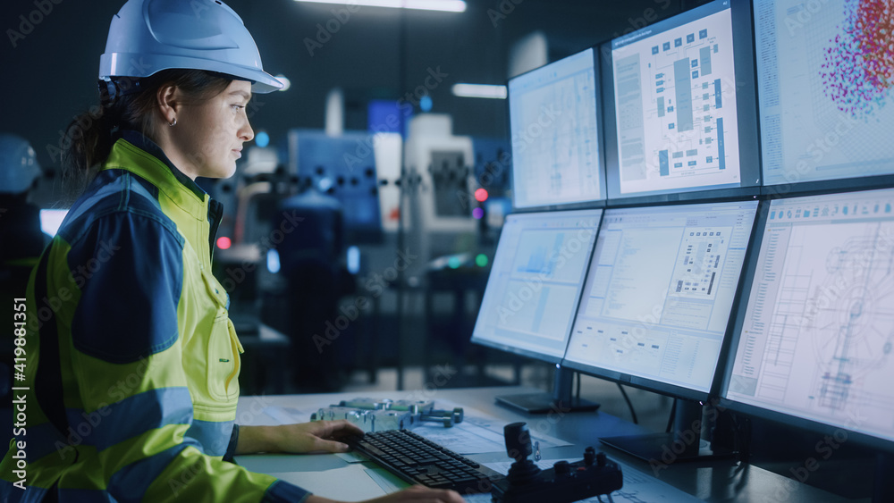 工业4.0现代工厂：女性设施操作员控制车间生产线，使用计算机