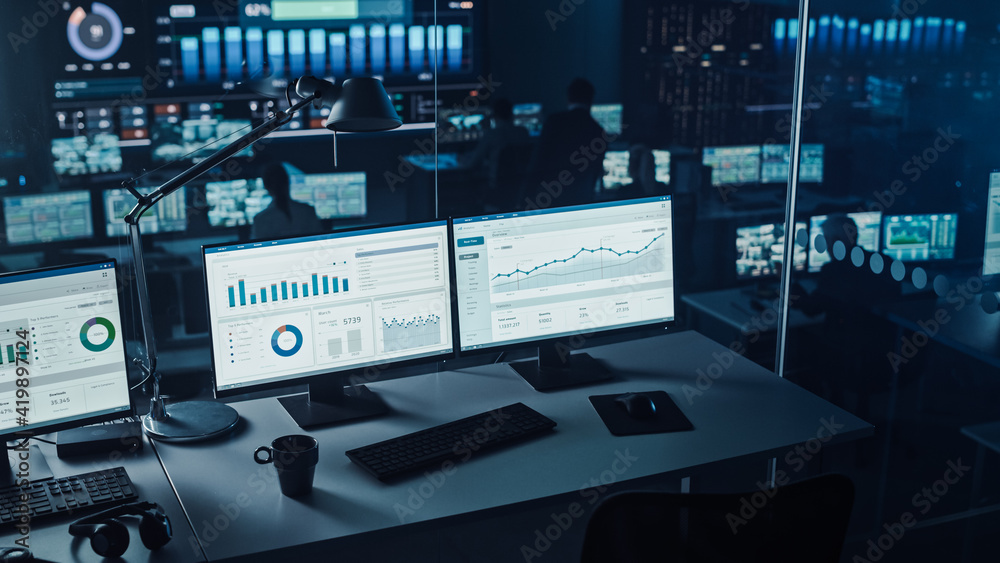 现代监控室的两个数字计算机屏幕和财务分析数据。控制室