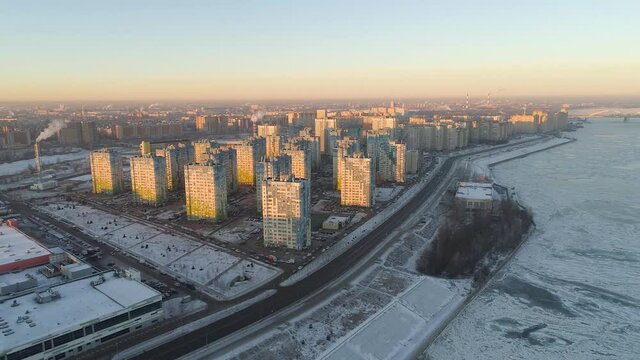 Flying over the city in the snow.A frozen river.Aerial photography.Top view.The beginning of winter