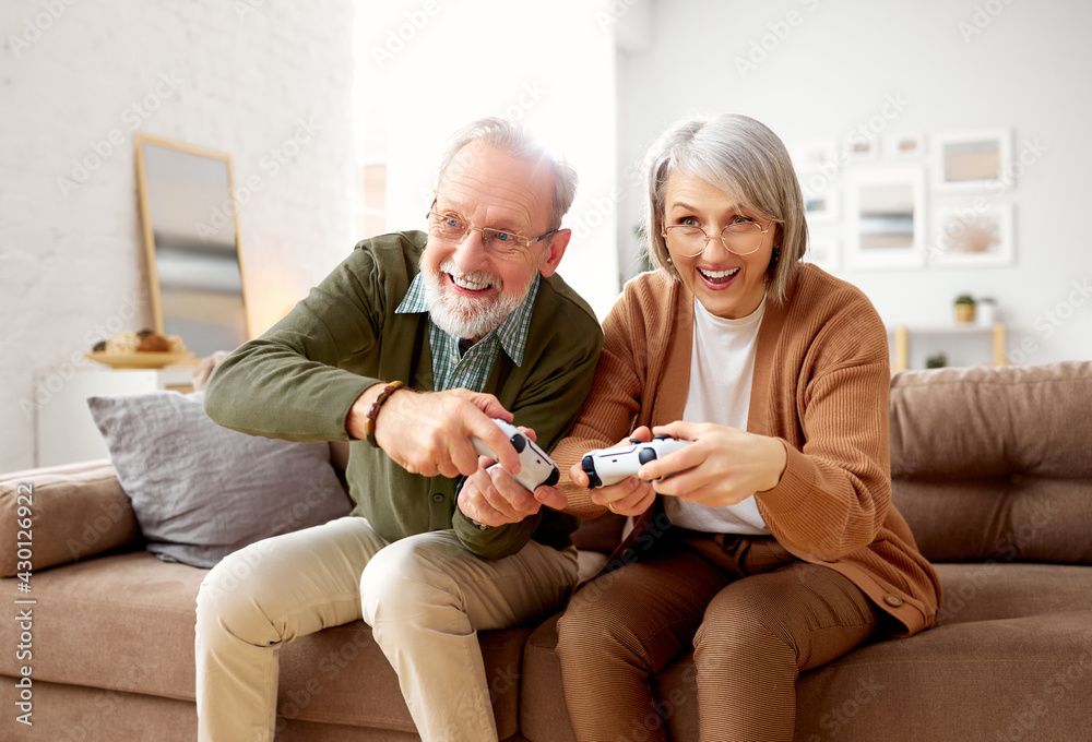 兴奋的老年夫妇在家玩游戏机