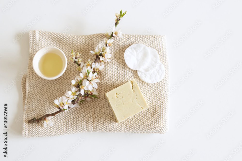手工制作的草药肥皂和杏仁油特写。杏仁树枝白色桌子背景。水疗概念。S