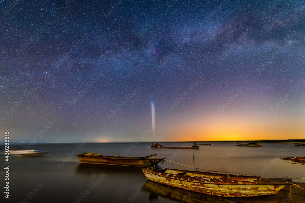 The milky way and star trails in the sky , lake side.