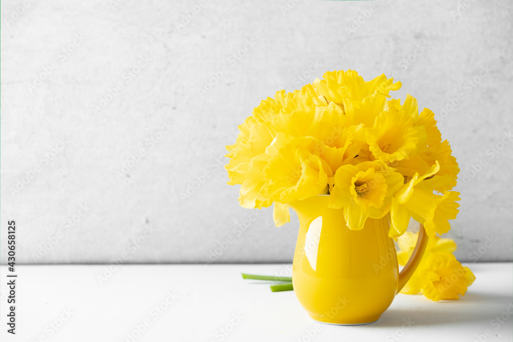 桌面上一个黄色罐子里的黄色水仙花花束，家居装饰，室内