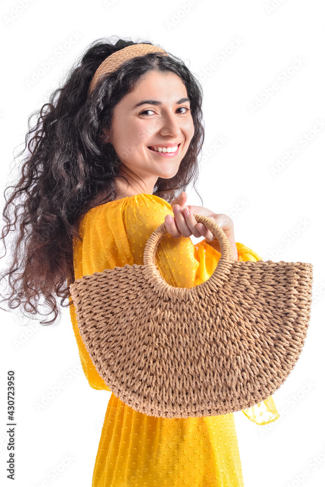 Portrait of fashionable young woman with wicker bag on white background