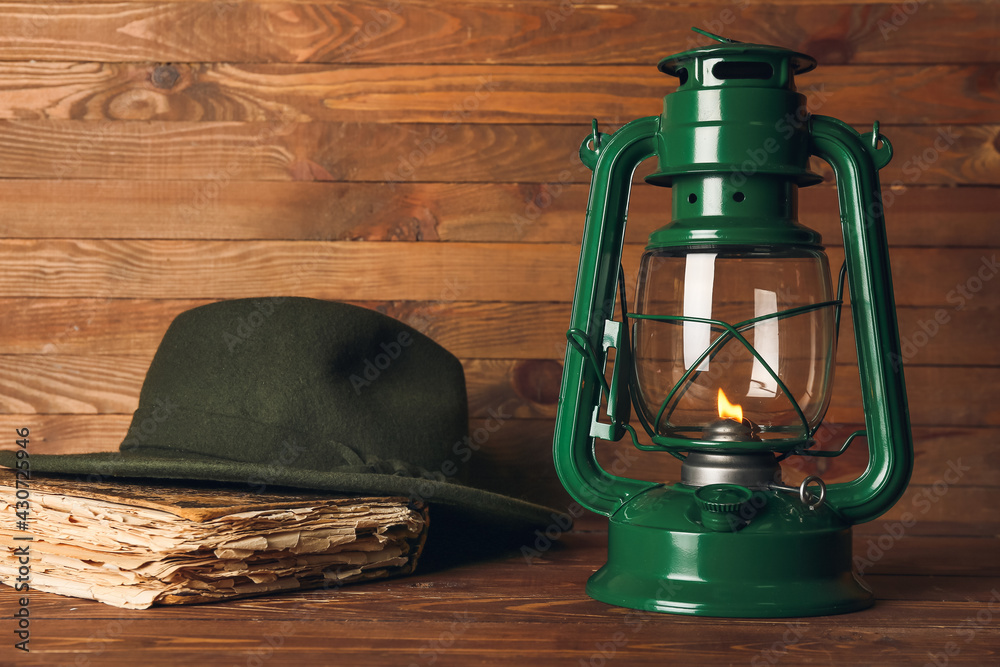木质背景的时尚复古灯具、帽子和书籍
