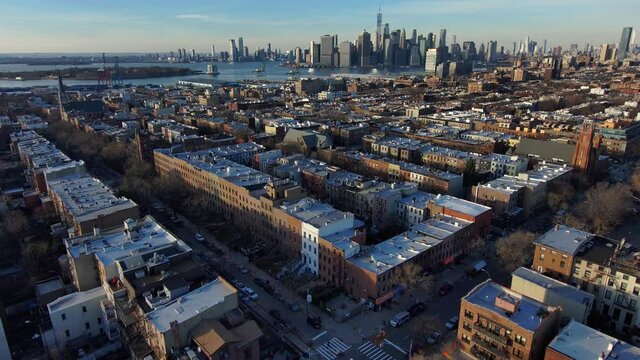 Excellent aerial establishing shot of Brooklyn apartments and residential district with manhattan New York city skyline distant.