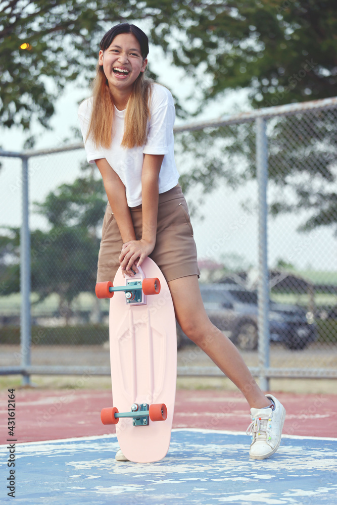 夏日户外冲浪滑板的亚洲女孩肖像。青少年生活方式。