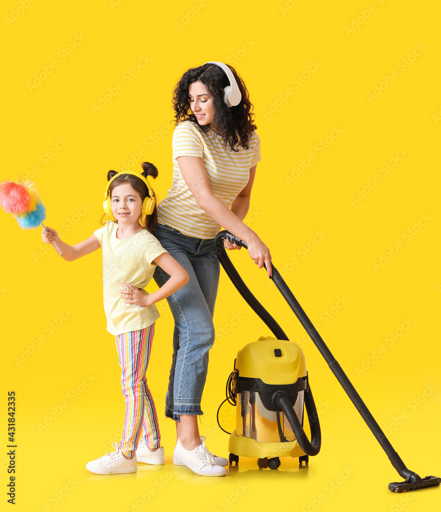 母亲和女儿带着彩色背景的吸尘器