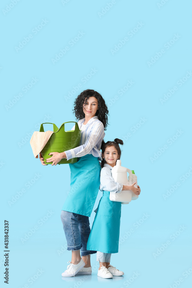 母亲和女儿用干净的毛巾和洗涤剂在彩色背景上