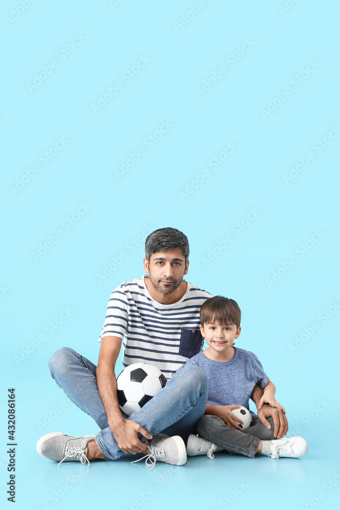 父亲和小儿子用彩色背景的足球