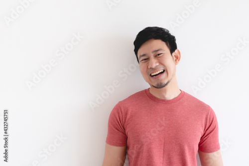 在孤立的背景下，欣赏穿着红色t恤的亚洲男子的笑脸。