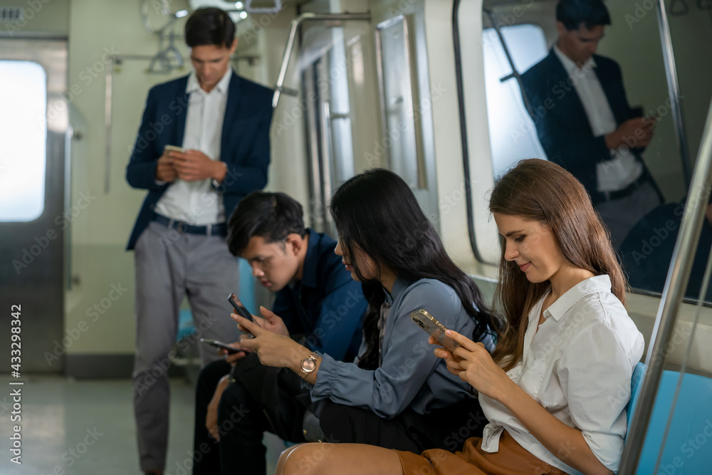 商务人士乘客在高峰时段上班时在地铁里使用智能手机。