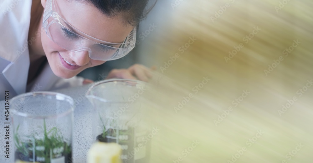 女性科学家在实验室用运动模糊的植物检查试管的组成