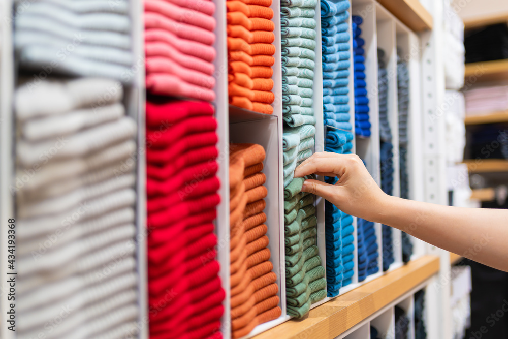 近距离女士在服装店货架上亲手挑选彩色棉袜