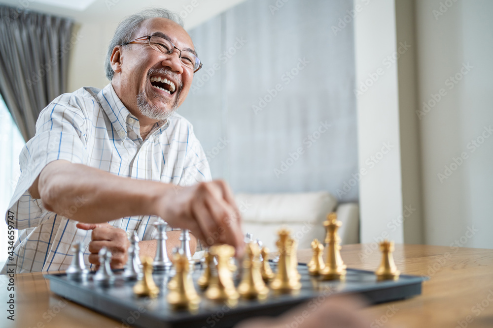 亚洲老人在疗养院空闲时间和朋友下棋。