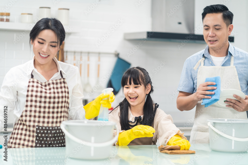 亚洲家庭互相帮助清洁厨房柜台和家务