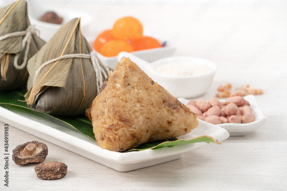 Zongzi. Rice dumpling for Dragon Boat Festival on bright wooden table background with ingredient.