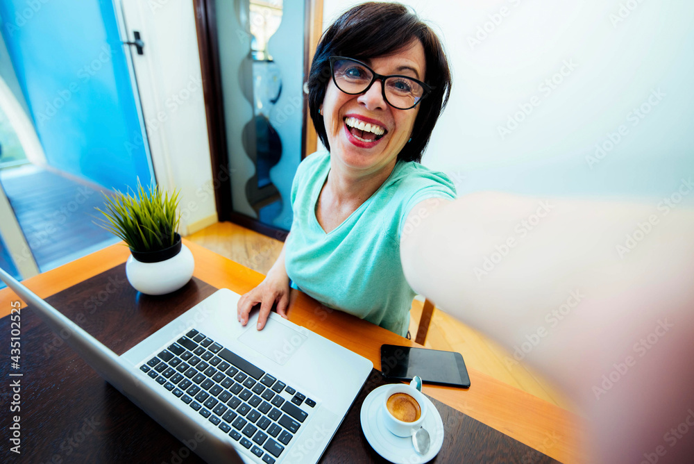 Senior woman wearing glasses using pc laptop computer working studying at home office sitting at tab