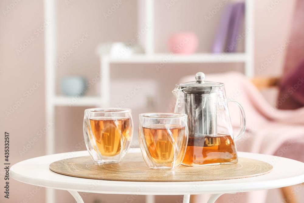厨房桌子上有热茶的茶壶和玻璃杯