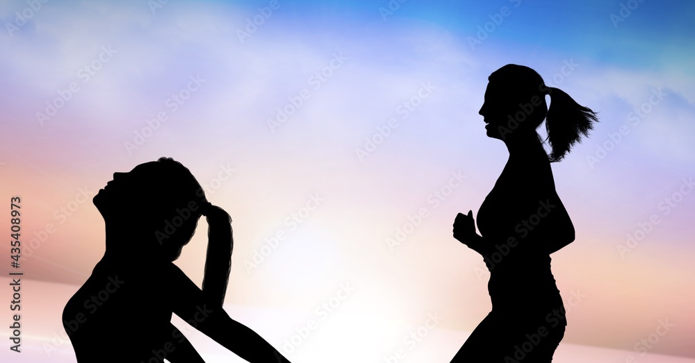 Composition of silhouette of fit women running and stretching against clouds on blue to pink sky