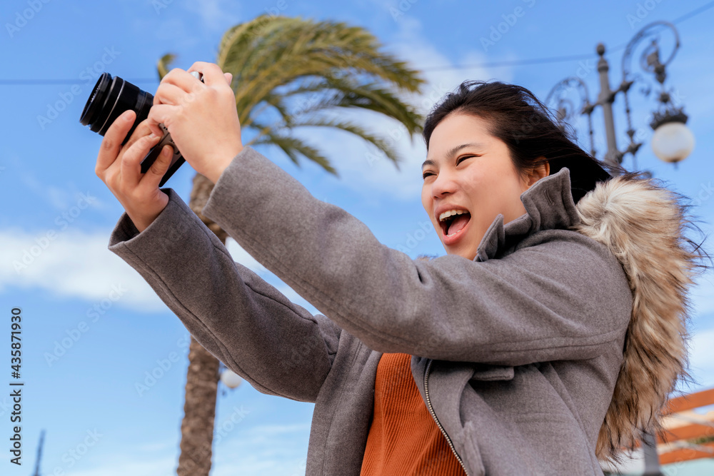 迷人的亚洲女性旅行者旅游手用相机观光海滩蓝天和棕榈树i