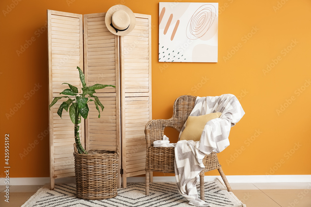 彩色墙附近的木制折叠屏风和扶手椅