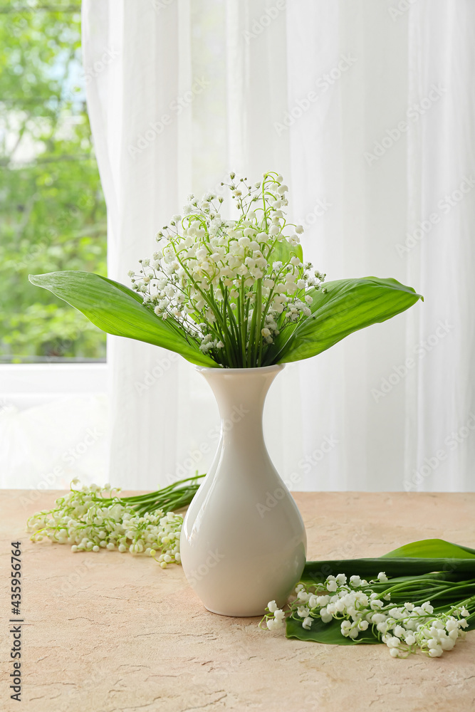 房间桌子上放着美丽的铃兰花的花瓶
