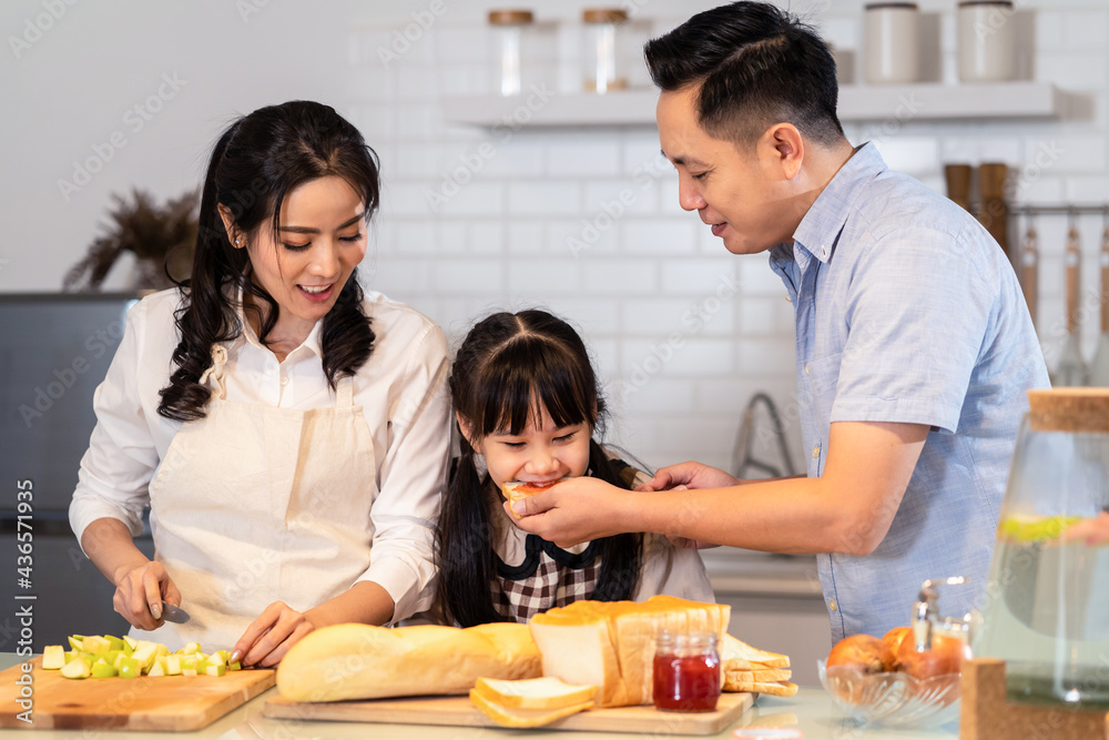 幸福的家庭，父母和女儿在厨房烘焙面包店和食品