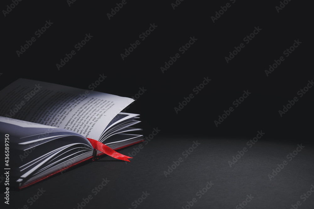 Open book with bookmark on dark background