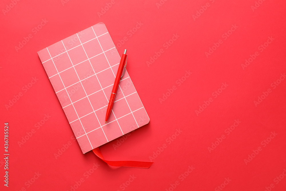 Notebook with bookmark and pen on color background
