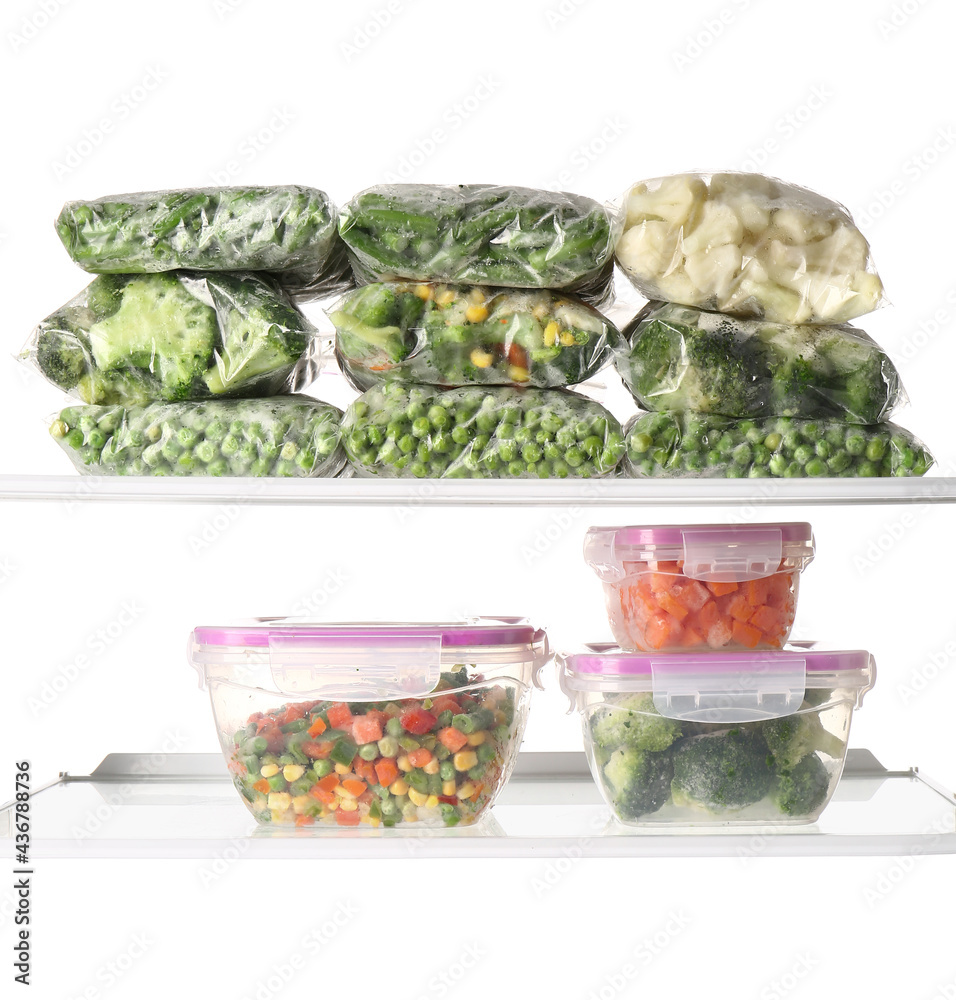 白色背景上装有冷冻蔬菜的塑料容器和塑料袋
