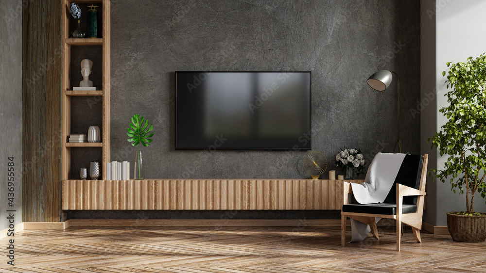 现代客厅里的电视模型，扶手椅和水泥墙背景上的植物。