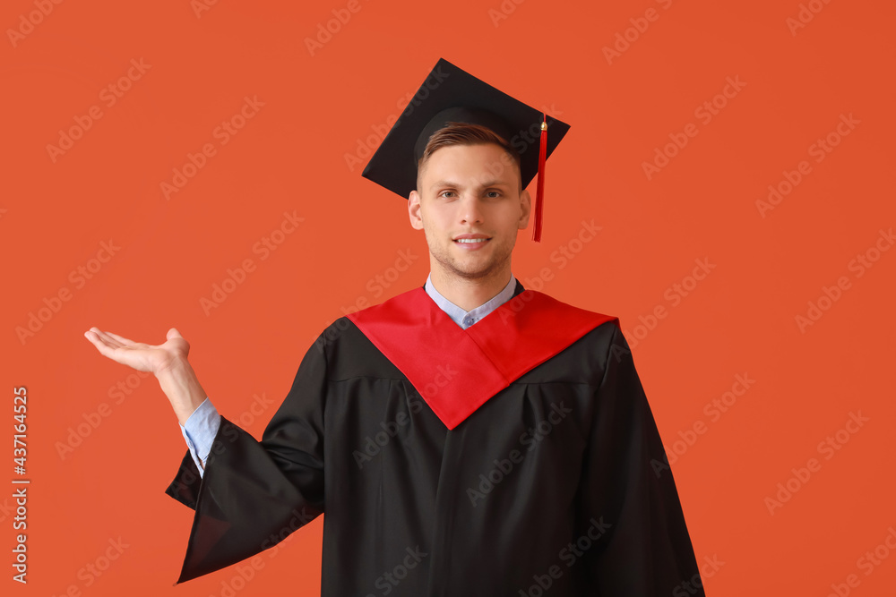 男毕业生在彩色背景上展示东西