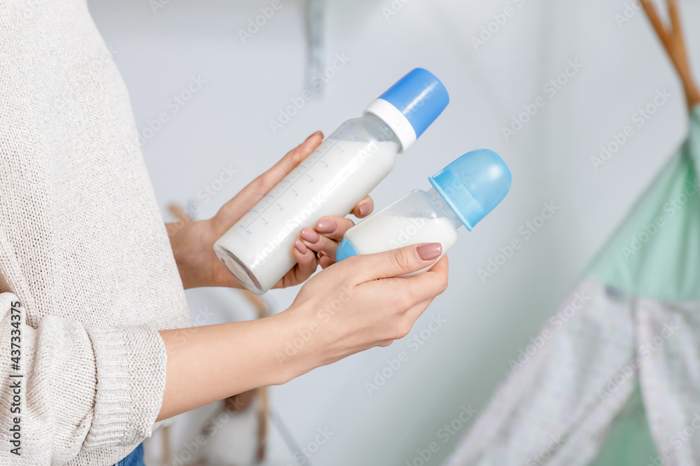 带着奶瓶给婴儿的女人，特写镜头