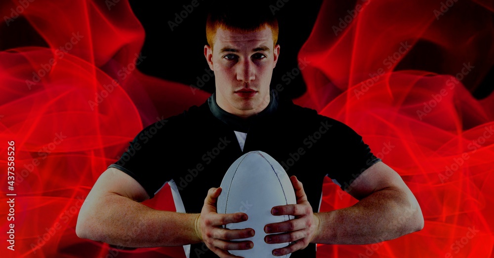 高加索橄榄球运动员在黑色背景下持球的合成，带有红色模糊